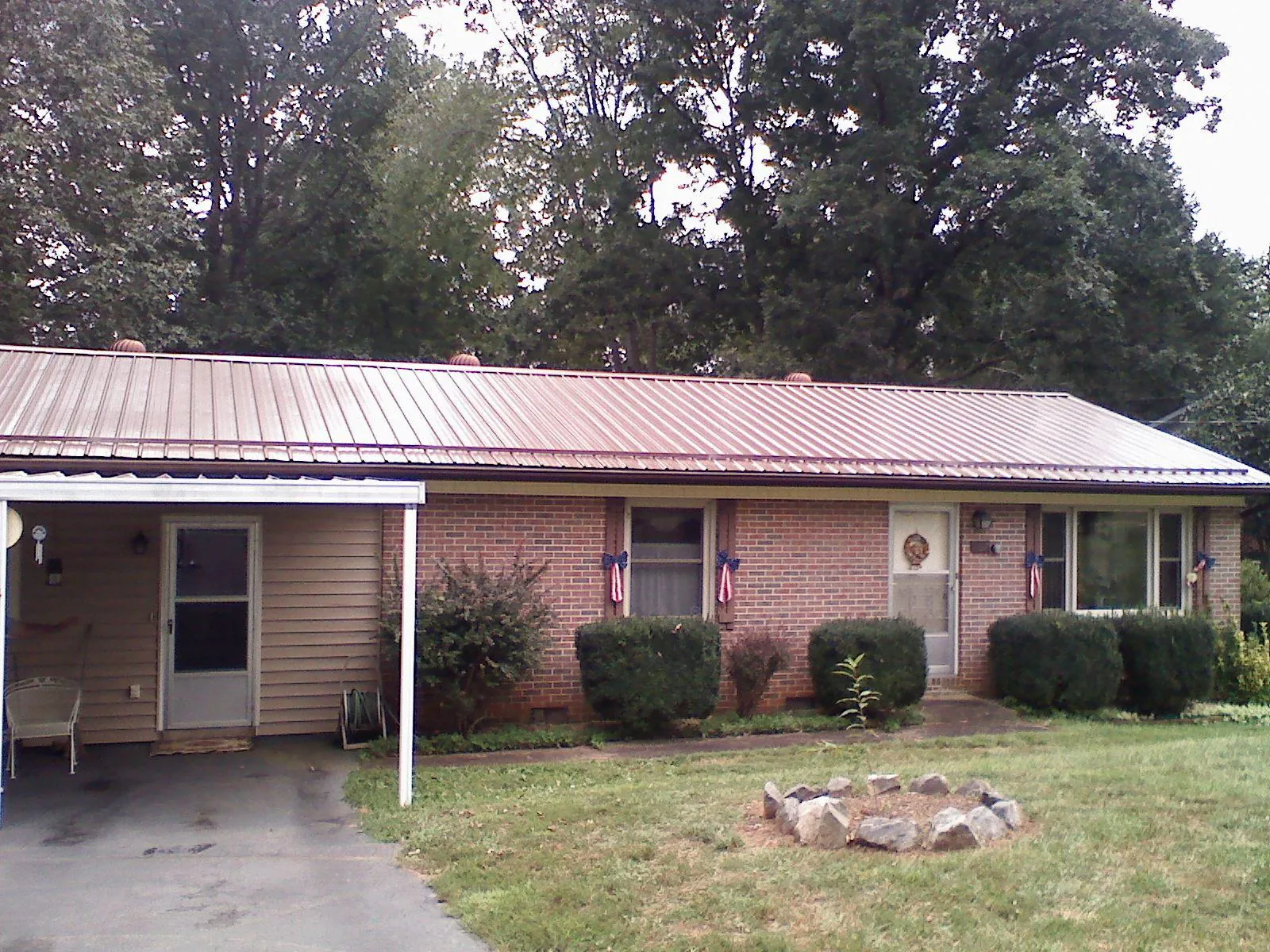 Bronze metal roof and carport on a brick ranch home — Roof Repair work by our crew in Cuddy